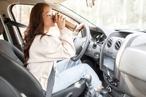 Viaggio di campagna in auto. Il modello femminile beve il caffè o il tè da un thermos . — Foto Stock