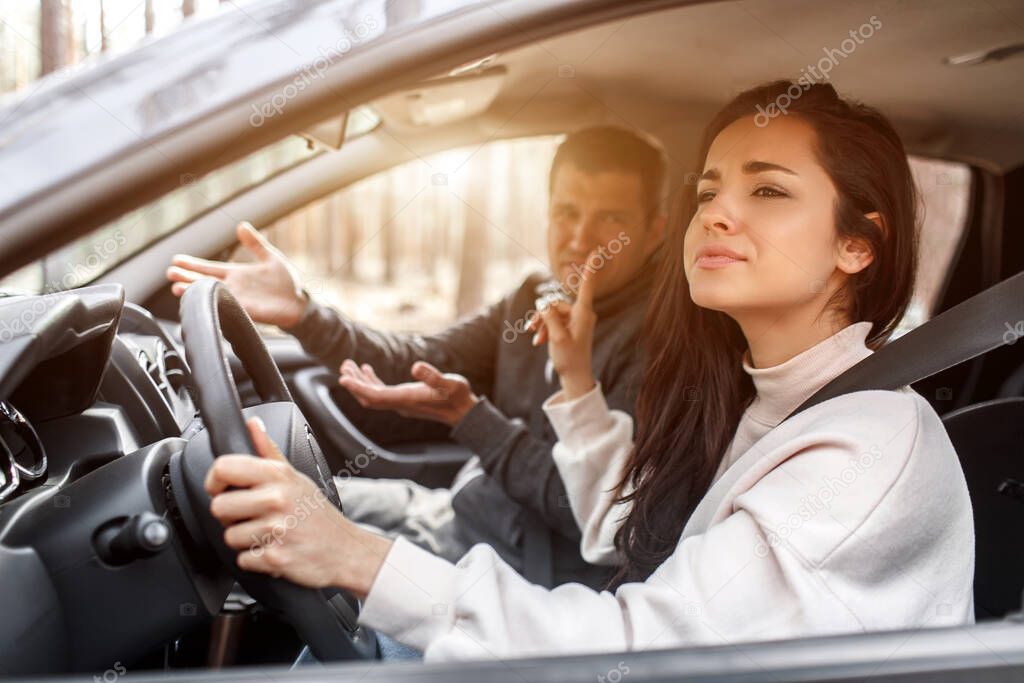 Driving instruction. A young woman learns to drive a car . Her instructor or boyfriend doesnt like the way she drives a car. But the girl is pleased with herself and does not listen to the guy.