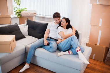 Taşındığı gün yeni evde karton kutuları olan mutlu bir çift..