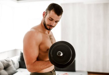 Genç, sıradan bir adam spor olsun diye evine gidiyor. Sıkı çalışan tişörtsüz bir sporcunun yerde durup dambılları elinde tutuşu. Antrenmana başlamaya hazırım. Sıradan bir adam vücudunu geliştirmeye çalışır..