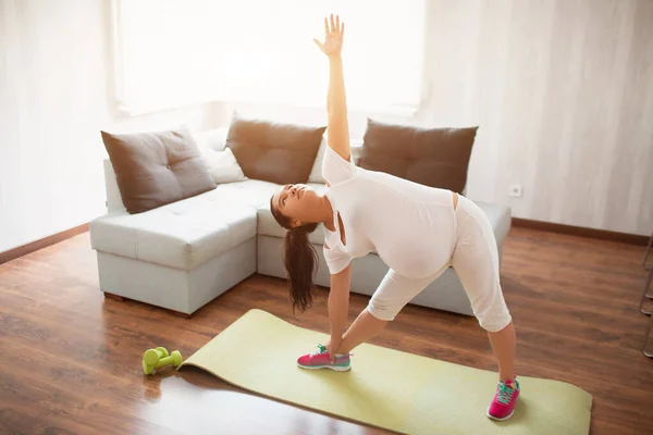 Ciężarna kobieta ćwiczy na macie do jogi w domu. Ciąża i sport. Oga i Pilates dla kobiet w ciąży. Trzeci trymestr ciąży — Zdjęcie stockowe