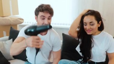 Genç çift yeni bir daireye taşınıyor. Saç kurutma makinesi tutan ve kızla dalga geçen adamın yavaş çekimleri. Kanepede birlikte eğleniyoruz. Paketleri açma ve açma zamanı.