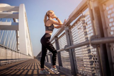 Yetişkin kadın koşucu köprüde..