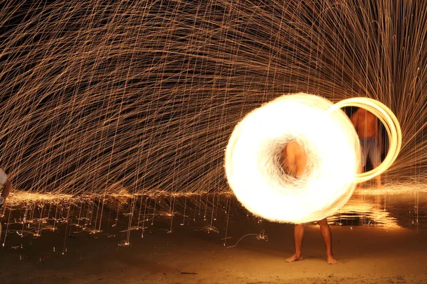 Geschicklichkeitsmann spielt Feuerwerk, indem er Holzstange mit Heizöl dreht — Stockfoto