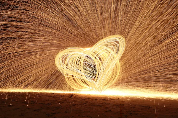 Geschicklichkeitsmann spielt Feuerwerk, indem er Holzstange mit Heizöl dreht — Stockfoto