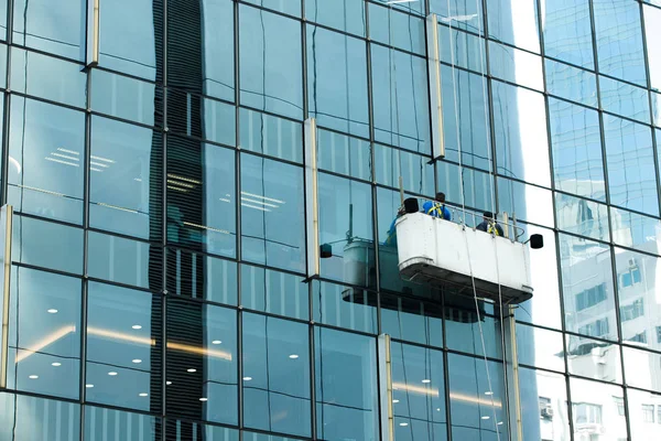 Pracovníci jeřáb kolébka čistá okna sklo vysoké — Stock fotografie
