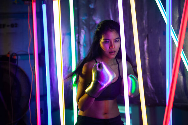 Азиатка тренируется и пробивает серебряные медали. Упражнения Office Girl в современном цвете Neon Muay Thai Boxing Gym с всплеском потной воды
