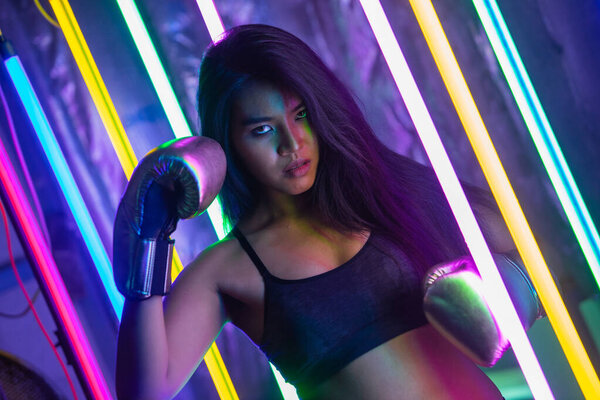 Красивая 20-х Азиатская женщина пунш, позы с серебряными золотыми перчатками перчатки. Упражнение Office Girl между современной многоцветной моды Неон Муай Тайский бокс тренажерный зал с всплеском потной воды
