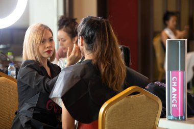 Udonthani, Thailand - July 23, 2019 ; Make up artist apply cosmetic to beautiful contestants for Miss Thailand 2019 Udonthani at Montatip Hall before show start