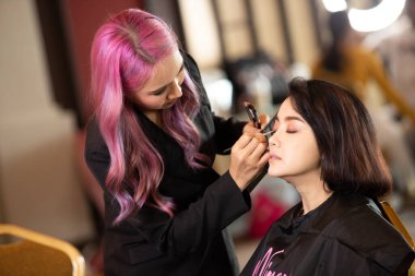 Udonthani, Thailand - July 23, 2019 ; Make up artist apply cosmetic to beautiful contestants for Miss Thailand 2019 Udonthani at Montatip Hall before show start