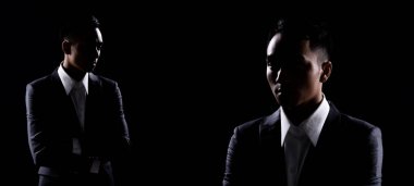 20 'li yılların Asyalı İş Adamı' nın Grup Kolajı stüdyo altında düşük pozlu arka plan karanlık arka plan, Doğru Gri Takım Elbiseli Erkek Gölge 'de birçok hareket, kopyalama alanı