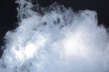 Dense Fluffy Puffs of White Smoke and Fog on Black Background, Abstract Smoke Clouds, Movement Blurred out of focus clipart