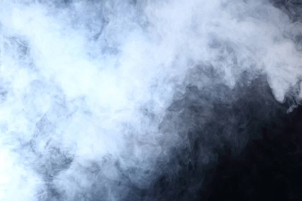 黒い背景に白い煙と霧の濃いふわふわのパフ 抽象的な煙雲 動きが焦点からぼんやりと — ストック写真