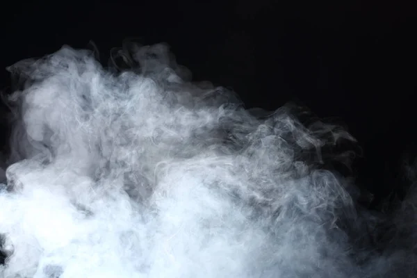 黒い背景に白い煙と霧の濃いふわふわのパフ 抽象的な煙雲 動きが焦点からぼんやりと — ストック写真