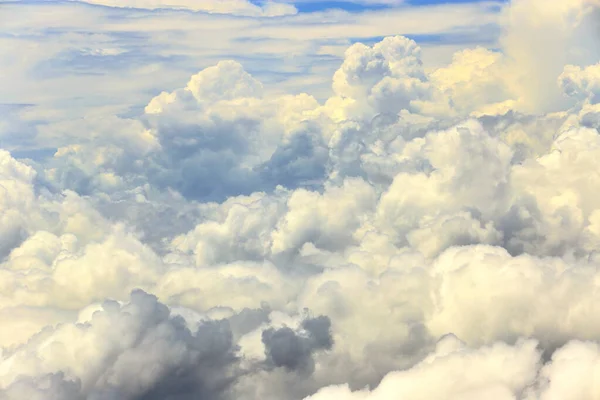 Dense Fluffy Puffs of White Clouds Blue sky at high level attitude, view from window airplane, copy space