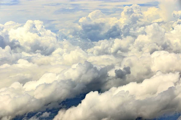 Dense Fluffy Puffs of White Clouds Blue sky at high level attitude, view from window airplane, copy space