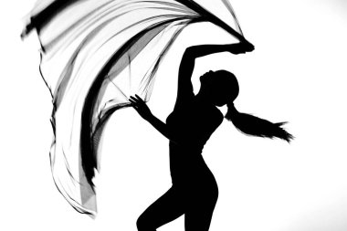 Siyah beyaz monokrom içinde şeffaf kumaş kumaşla dans eden kadın kıyafetinin silueti. Stüdyoda seksi vücudu göstermek için çırpınan hareketler ve bulanık hareketler.