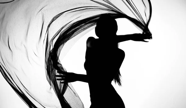 シルエットの女性のボディスーツダンスで透明生地の布で黒と白のモノクローム なびく投げ動きとぼかしの動きで示すためにセクシーなボディでスタジオ — ストック写真