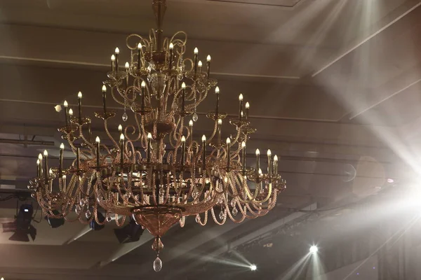 Par Lights beams Spotlight ray moving lighting blinking on rack construction to chandelier in Hotel Ballroom