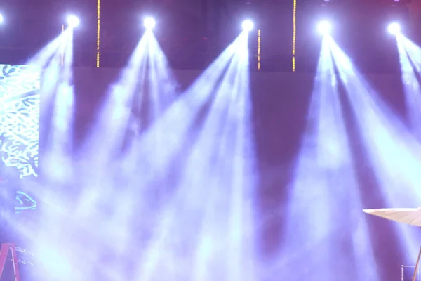 Performance moving lighting on construction light beam ray downward in yellow blue color, on Concert and Fashion Show stage ramp with smoke