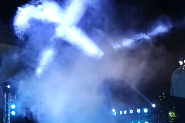 Performance moving lighting on construction light beam ray downward in yellow blue color, on Concert and Fashion Show stage ramp with smoke