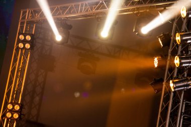 Sahne rampası ve konserde, inşaat ışığı ışınlarını aşağı doğru sarı renkte, aşağıya doğru hareket ettirme performansı