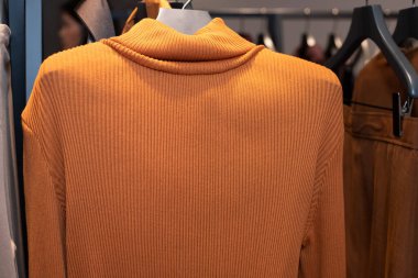 Perakende mağazasında moda tasarım kıyafetleri, yeni koleksiyon turuncu kaplumbağa boynu günlük elbise vitrinlerde satışta moda tasarımcısı hizmetleri sonbahar kış mevsiminde, uzay metin logosunun kopyası.