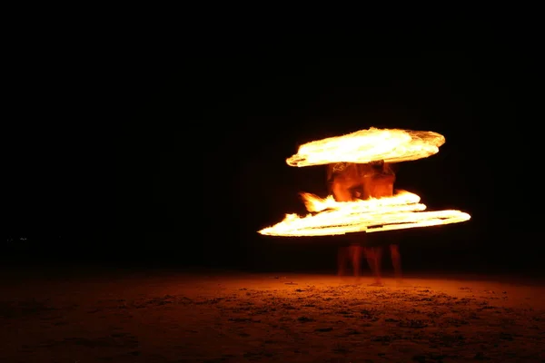 기술을 남자가 장수철을 밑으로 돌리며 불꽃놀이를 다를따라 해변에서 불이둥그렇게 장시간 — 스톡 사진