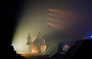 Siluet Gölge Modelleri akşam balosu elbisesi gösteri rampası pistinde Lighting 'den duman içinde çıktı. Fotoğrafa tahıl ve gürültü ekleyerek çok düşük ışığa maruz kalma