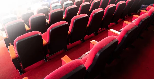 电影院音乐会或西米娜会议室内的红色天鹅绒织物清空许多座位排的背景图 — 图库照片