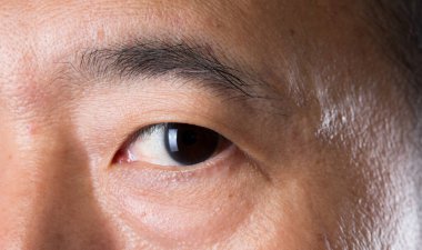 İnsan gözünün yakın çekim makro portresi, gündüz makyajlı açık kahverengi gözlü insan erkek. Orta yaşlı, 40 'lı yaşlarda, mükemmel sivilce derisi ve derin çilleri olan bir adam..