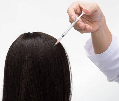 Estetik Doktoru, yaşlı bir kadının çalışmasını önlemek için şırınga, siyah saç dökülme terapi kliniği ve stüdyo ışıklandırması için saç dökülme bölgesine serum vitaminleri enjekte ediyor.