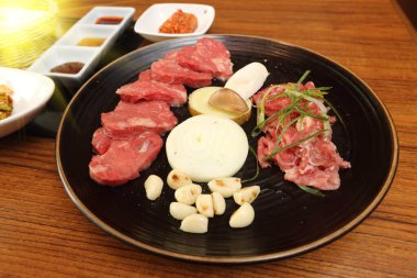 Restoranda yemek ahşap masada sığır eti unyank gwangyang dilimlenmiş et ızgara domuz eti marine edilmiş boyun eti.