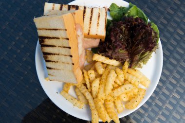 Klasik tavuk şamandırası kızarmış yumurtalı sandviç patates kızartması, kızarmış sebze, füzyon yemek stili okyanus mangrov ağacı adası boyunca cam masada düzenleme, metin logosu için boş fotokopi alanı