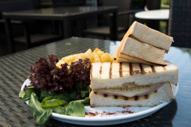 Klasik tavuk şamandırası kızarmış yumurtalı sandviç patates kızartması, kızarmış sebze, füzyon yemek stili okyanus mangrov ağacı adası boyunca cam masada düzenleme, metin logosu için boş fotokopi alanı