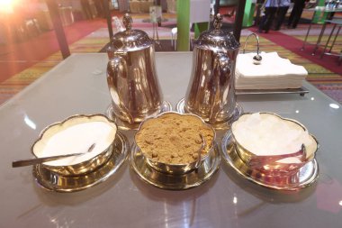 Kahve, çay, sıcak içecek ve konferans odasında cam masanın üzerinde kağıt mendil ve tatlı malzemesi için kahverengi beyaz tuğla şekeri kapatın.