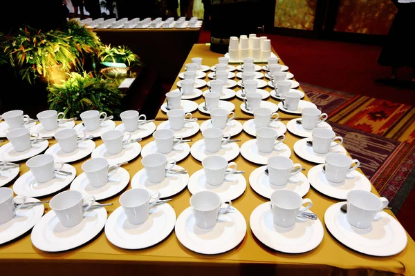 Group of empty coffee cups.Many rows of white cup for service tea or coffee in breakfast or buffet and seminar event. white cup in Catering and Cocktail with blurred people background