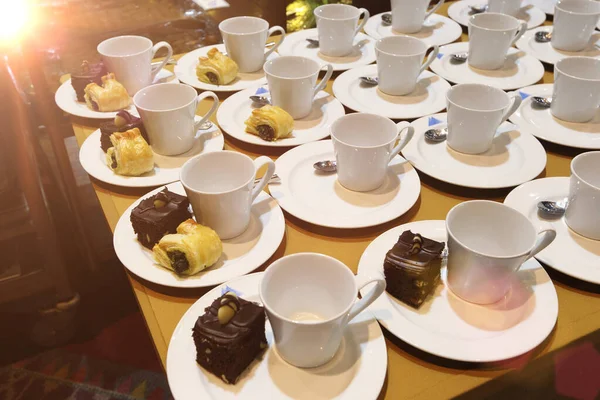 Group of empty coffee cups.Many rows of white cup for service tea or coffee in breakfast or buffet and seminar event. white cup in Catering and Cocktail with chocolate cake and snack