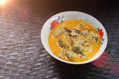 Tayland usulü yeşil körili tavuk ve yanında Rattan tepsisi.