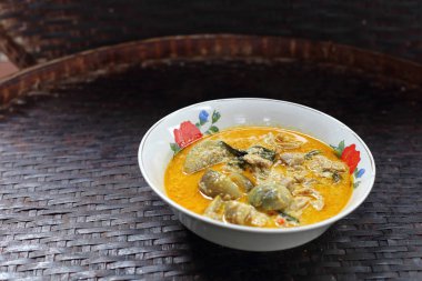 Tayland usulü yeşil körili tavuk ve yanında Rattan tepsisi.