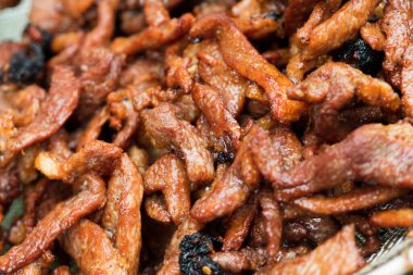 Yol tedarikçisi tarafından sokak yemeği olarak haşlanmış yağ tenceresinde büyük miktarda domuz eti parçaları satılıyor. Et yumuşak ve çıtır çıtır. Yerel halk için yapışkan pirinçli ünlü yiyecekler seçici bir odak noktası.