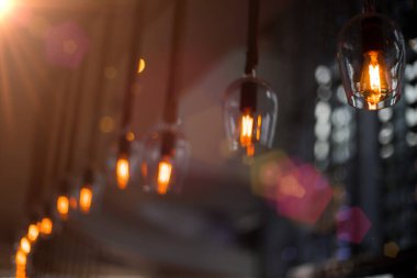 Lokantada asılı duran elektrik ampulü bar dekorasyonu, çelenk süslemesi klasik ampul tasarımı ve yan odaya kadar bulanık görüş açısı, dükkânda akkor süsleme.