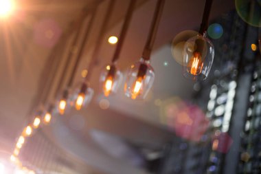 Lokantada asılı duran elektrik ampulü bar dekorasyonu, çelenk süslemesi klasik ampul tasarımı ve yan odaya kadar bulanık görüş açısı, dükkânda akkor süsleme.