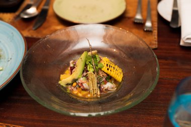 Baharatlı salata sebze, kalamar, karides, mısır sosu. İspanyol mutfağı, ahşap masa üzerinde biraz sıcak ve eşsiz bir tadı var..