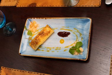 İçinde sarı rulo ve dondurma var. Tabakta gizli sos var. İspanyol mutfağı mutfağı. Tahta masada biraz sıcak ve eşsiz bir tadı var..
