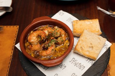 Karides, baharat, baharat, baharat, gizli tarif soslu ekmek, bir tabak İspanyol mutfağı, ahşap masada biraz sıcak ve eşsiz bir tadı var..