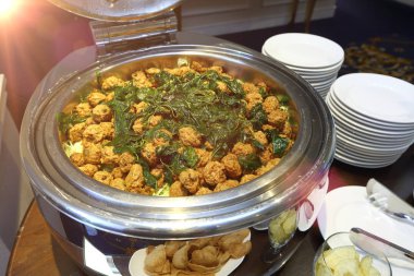 Kızarmış balık köftesi Tayland yemeği ve çıtır fesleğenli, yuvarlak paslanmaz haşlanmış tencere ve meze.