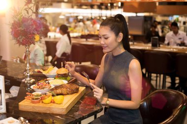 Çalışan Asyalı Kadın Siyah Saçlı Büyük Parça Biftek Izgara Akşam Yemeği Füzyon Restoran Kafe 'de ve yalnız yemek. İyi bir yemek için kendimi yemekten zevk alıyorum.