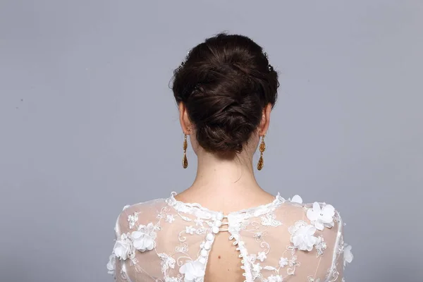 Hair Styling turn back View, Black color caucasian Bride hair style, White Wedding Lace Dress beauty shoot, studio lighting gray background