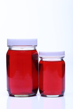 Kırmızı Sıvı, iki şişe beyaz kapaklı grup, stüdyo ışıkları beyaz arka plan izole